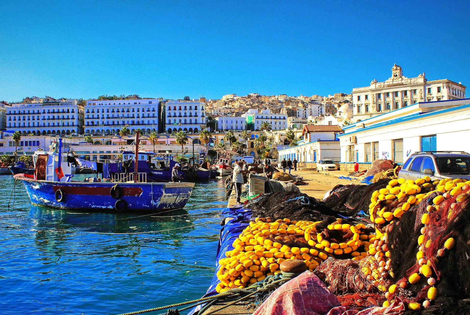 Blå fiskebåt vid kajen i Algeriet