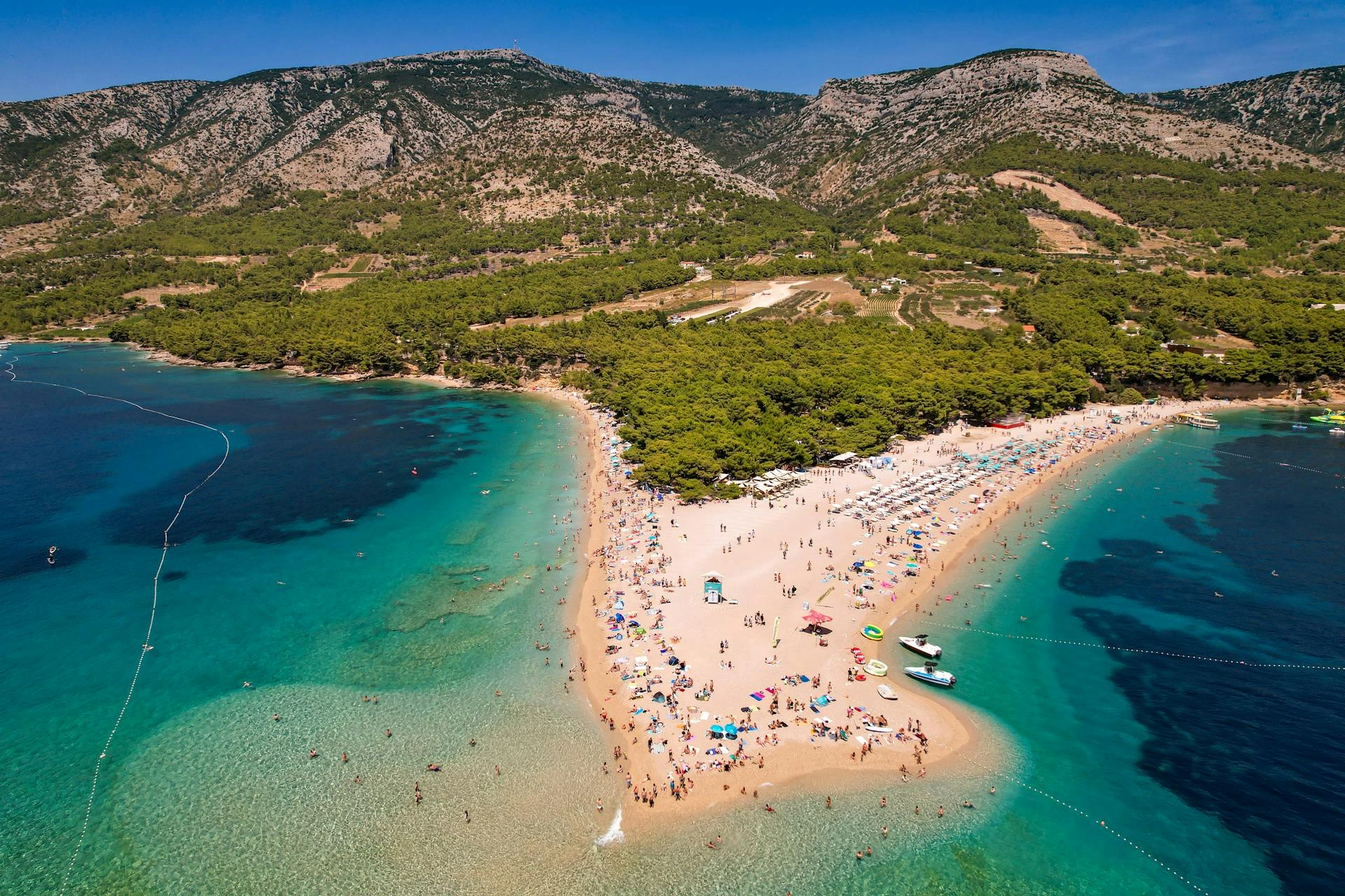 Strand med blått vatten och gröna berg, Kroatien
