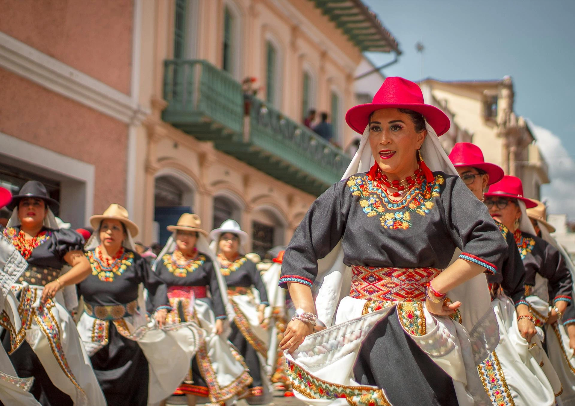Kvinnor i färgglada traditionella kostymer i parad, Ecuador