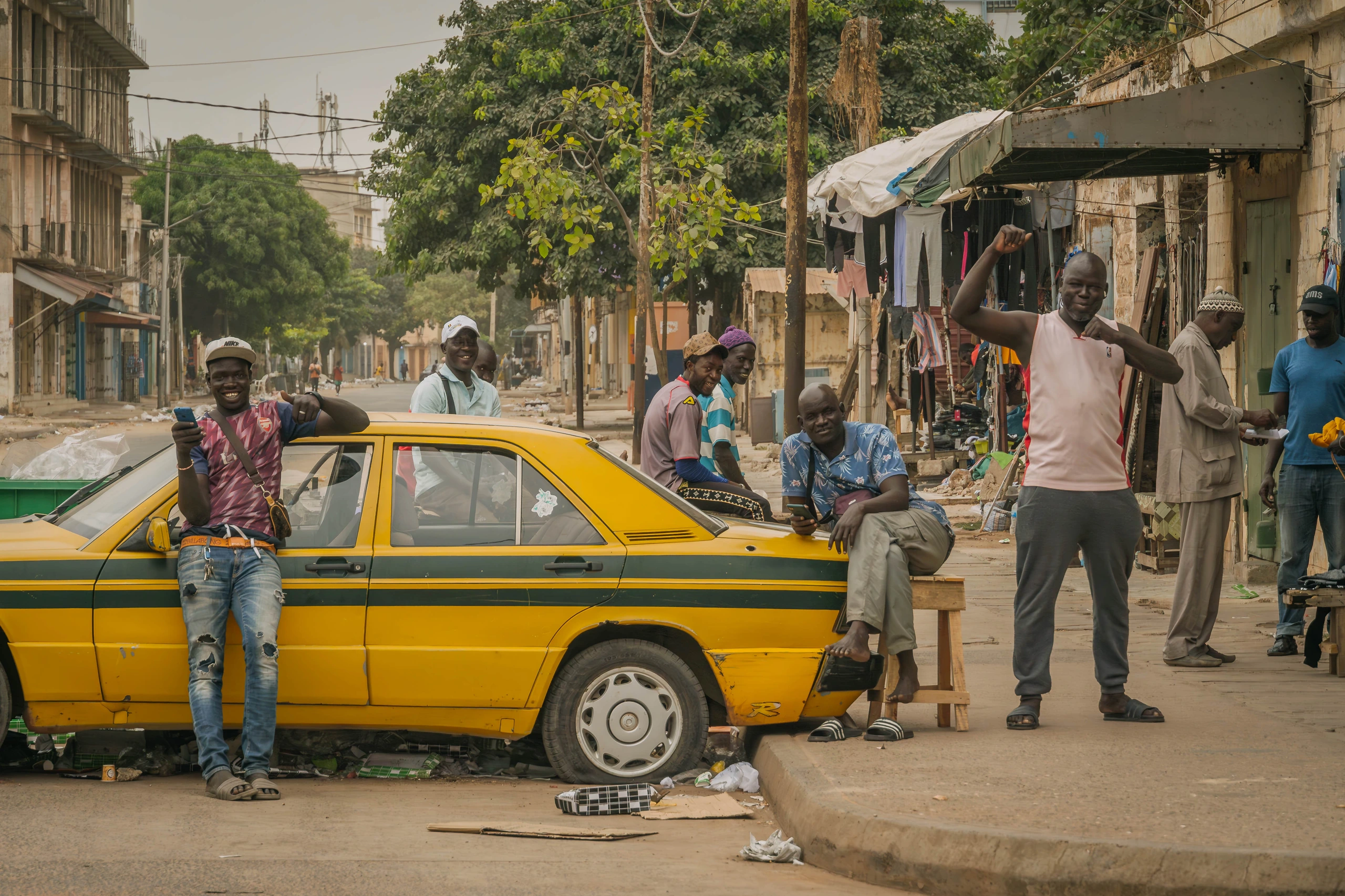 Män vid gul taxi i Banjul, Gambia