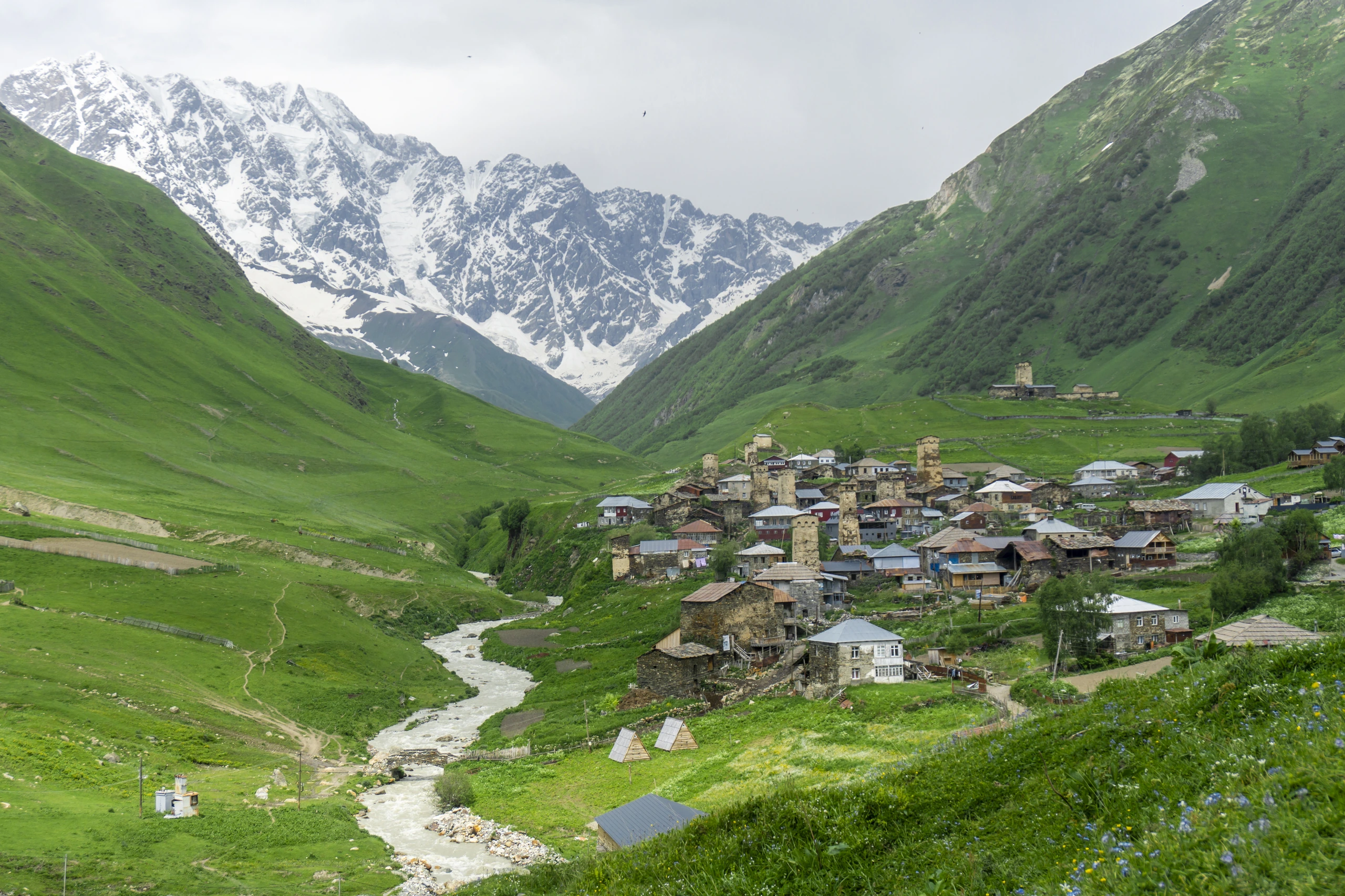 Ushguli by i Georgien med snötäckta berg