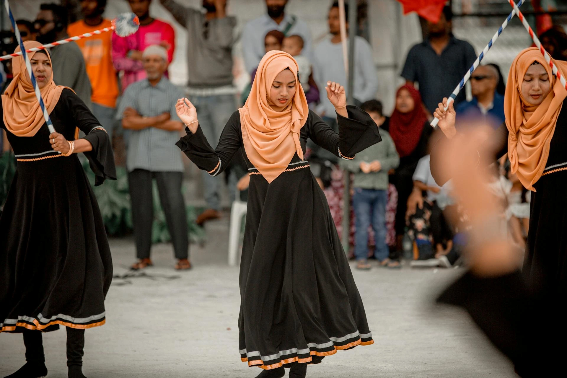 Kvinnor i orange huvudduk dansar traditionellt, Maldiverna