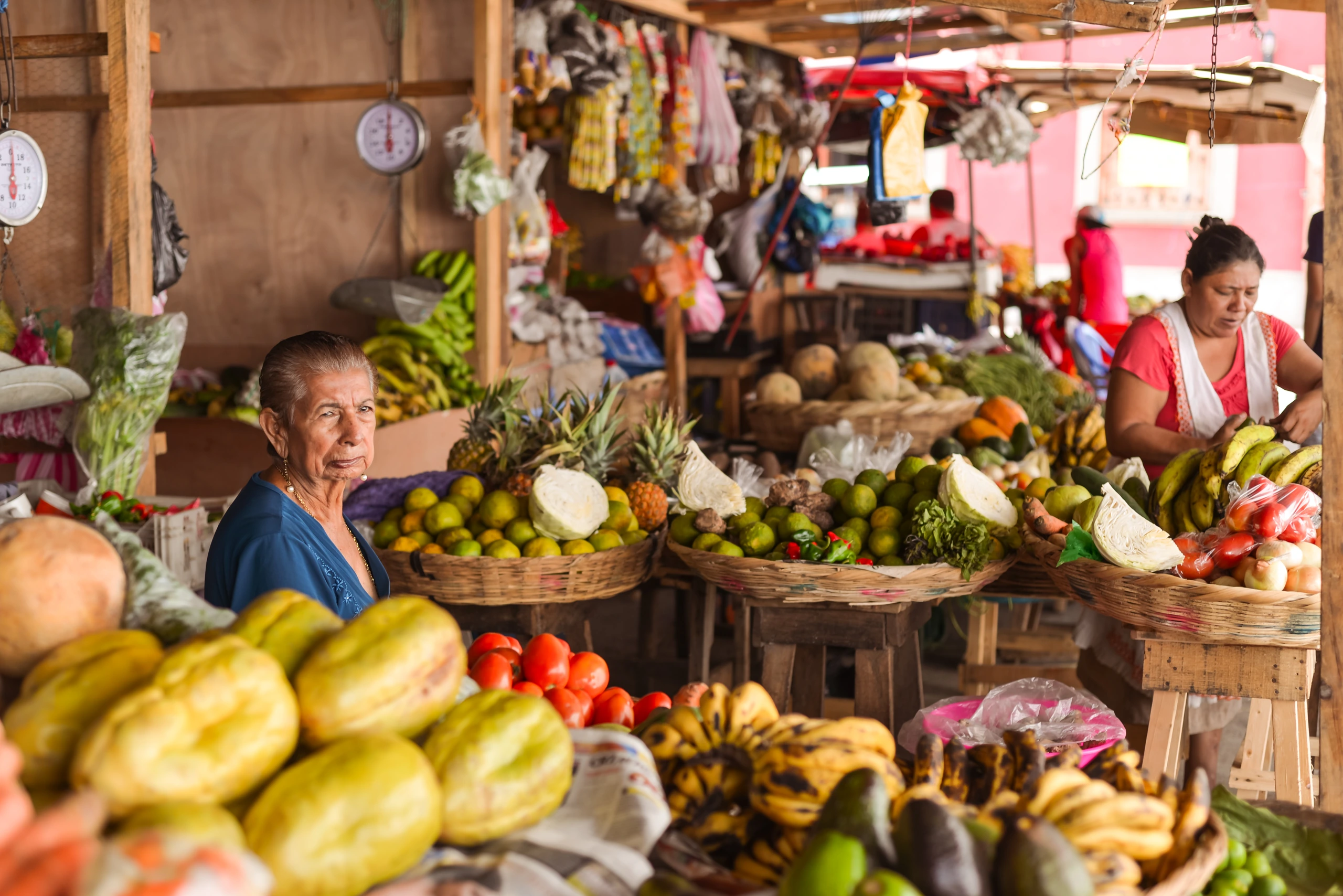 Nicaraguansk kvinna på marknad med färgglada grönsaker, Nicaragua