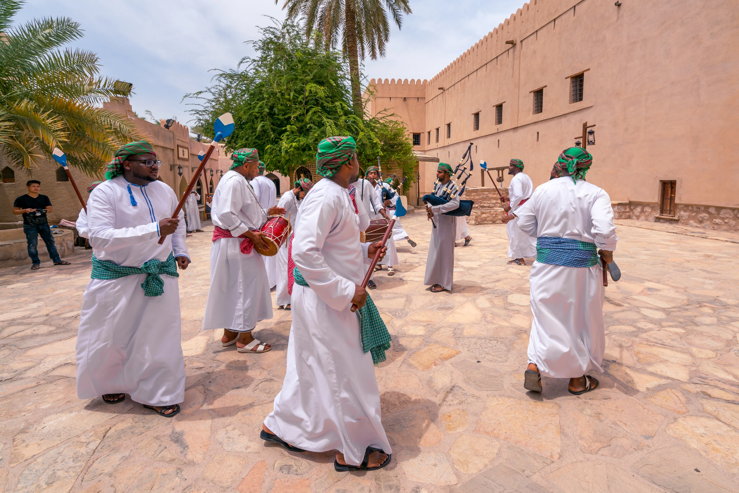 Män i traditionell dräkt dansar i Oman