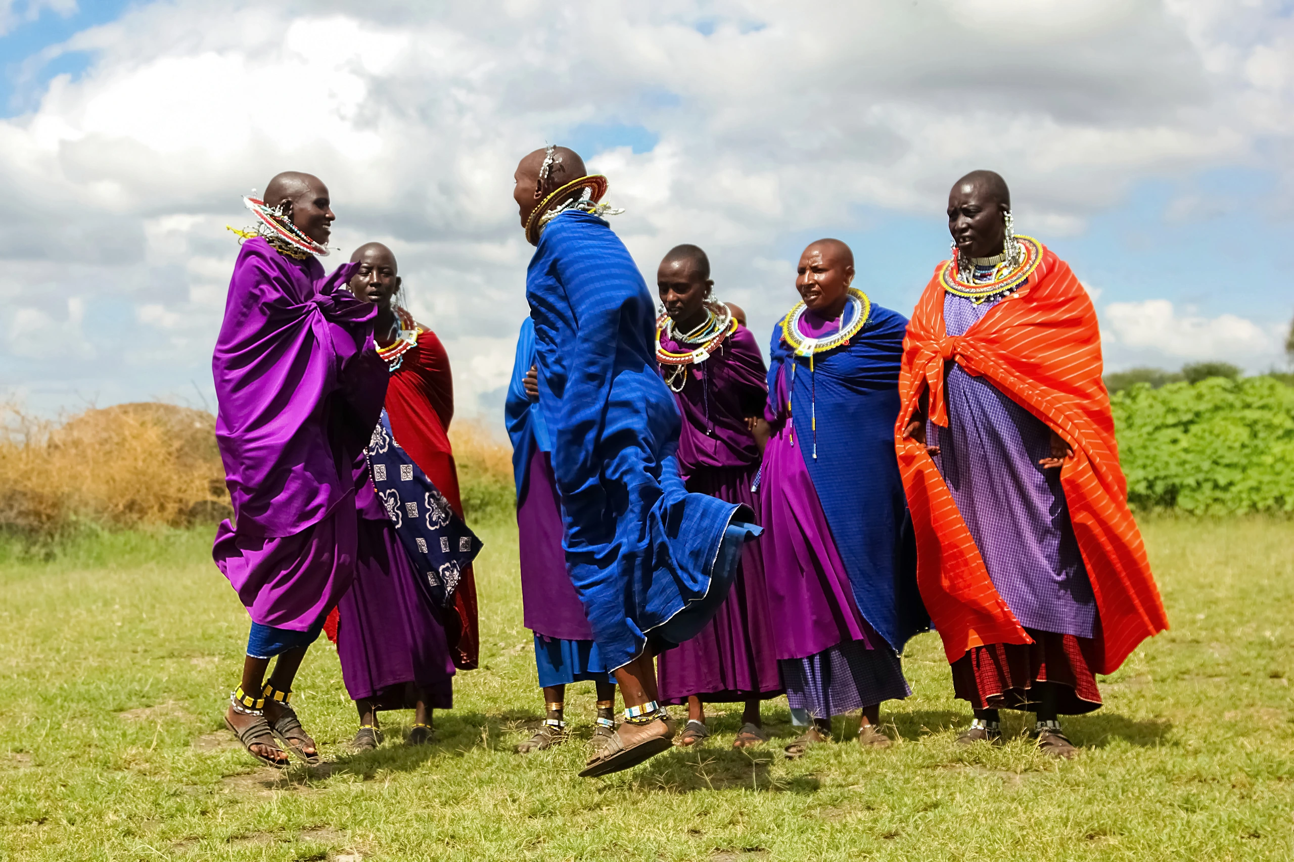 Masai-kvinnor i färgglada kläder dansar, Tanzania