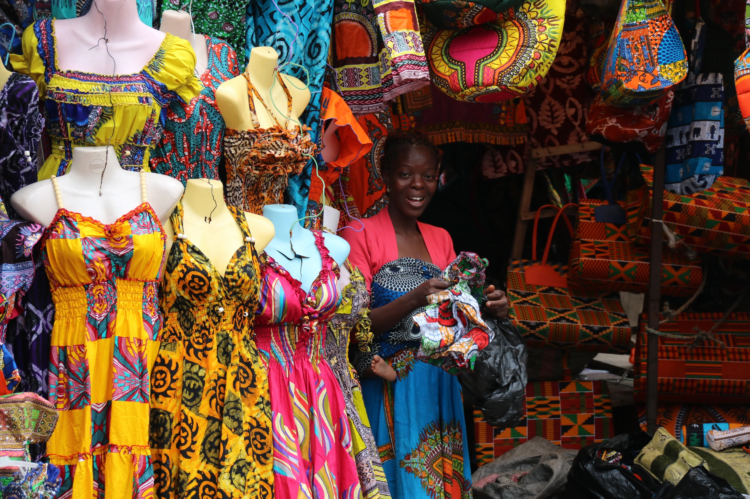 Kvinna säljer afrikanska textilier i Lomé, Togo