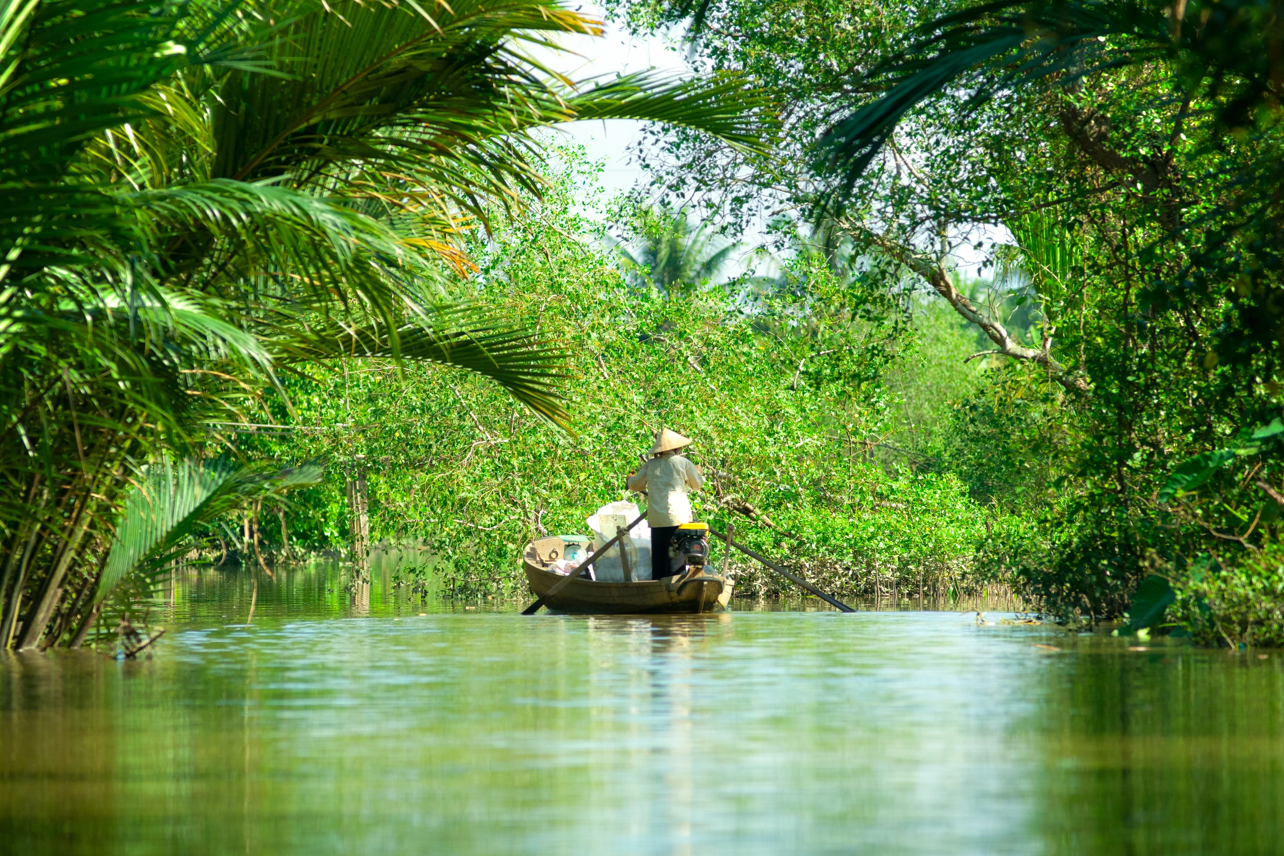 Kvinna som kör båt i Mekongdeltat, Vietnam